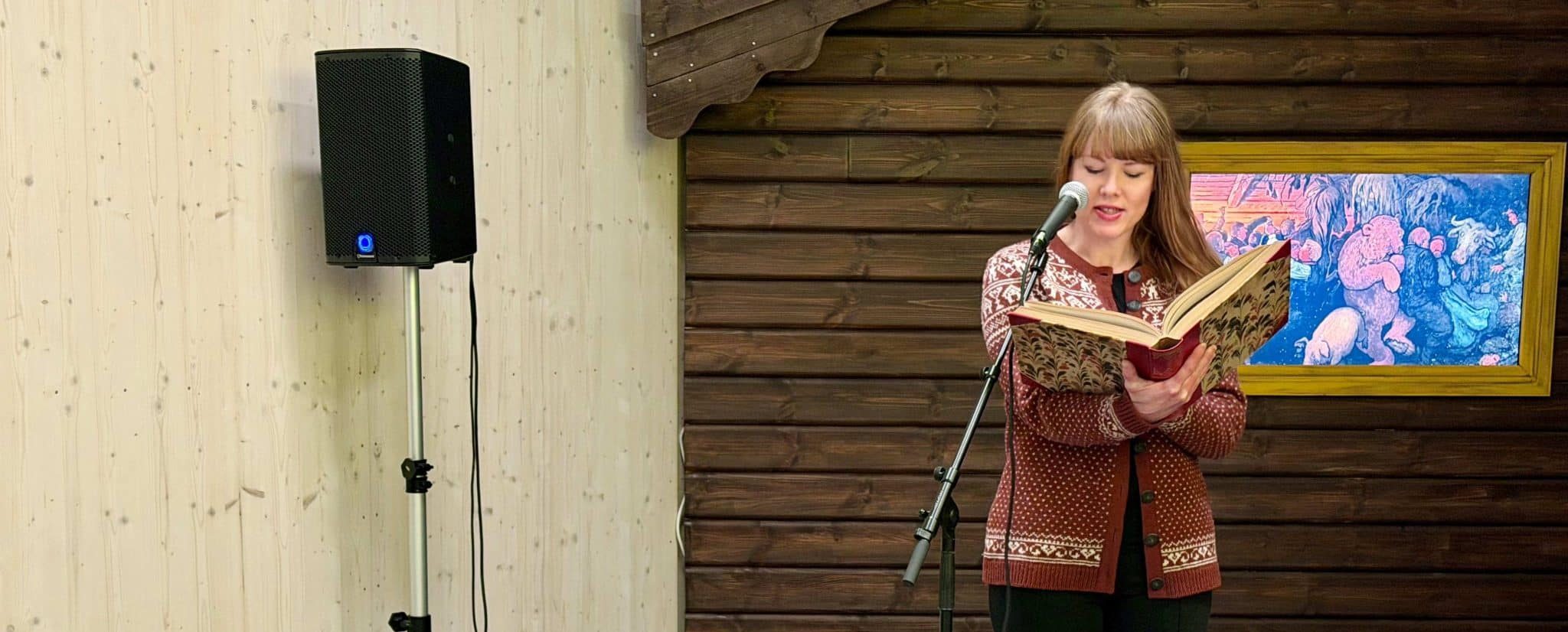 Karen K. Erikstad leser eventyr, stående ved en mikrofon