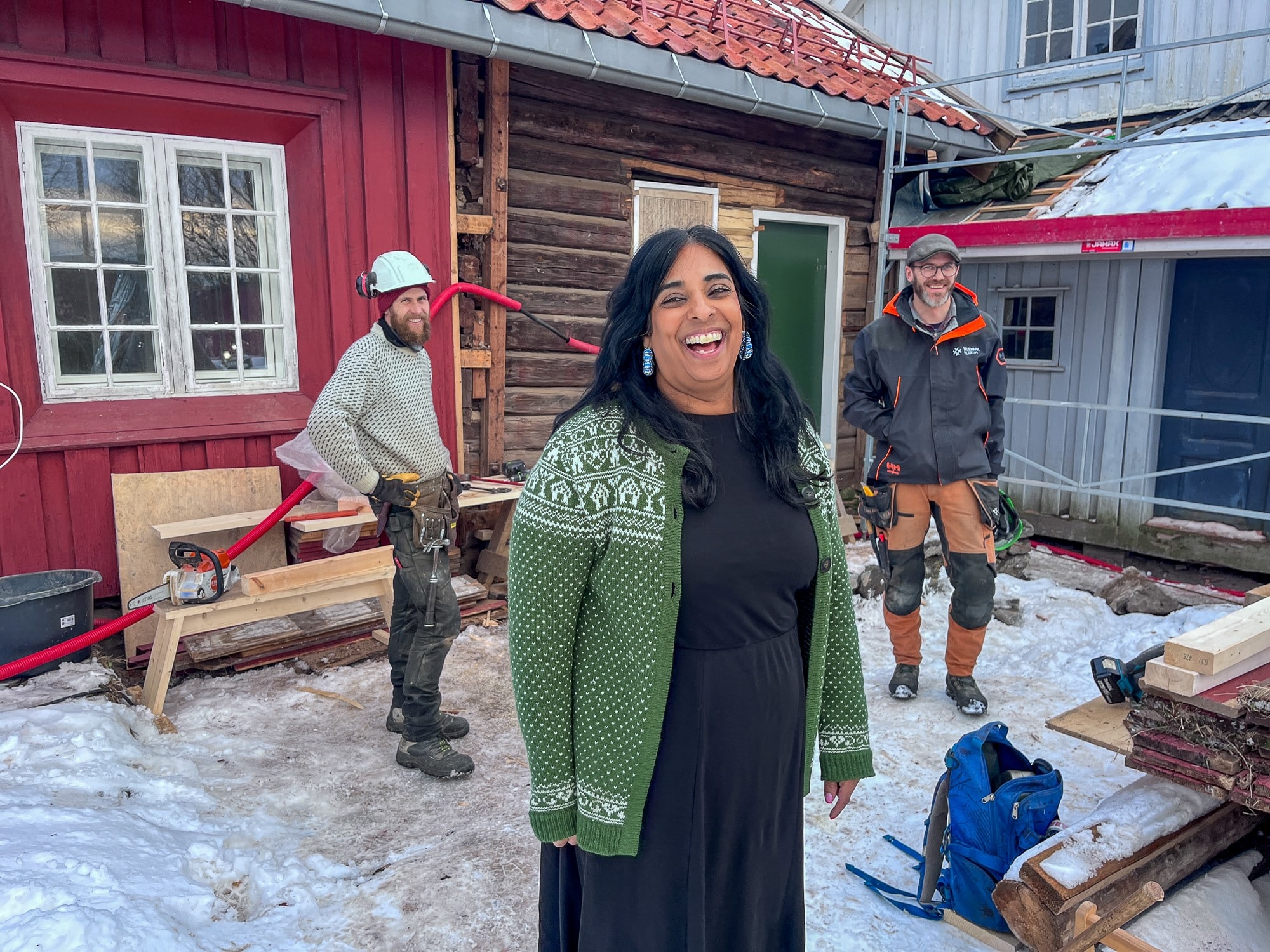 Lubna Jaffery utenfor huset på Venstøp. Bak står to håndverkere